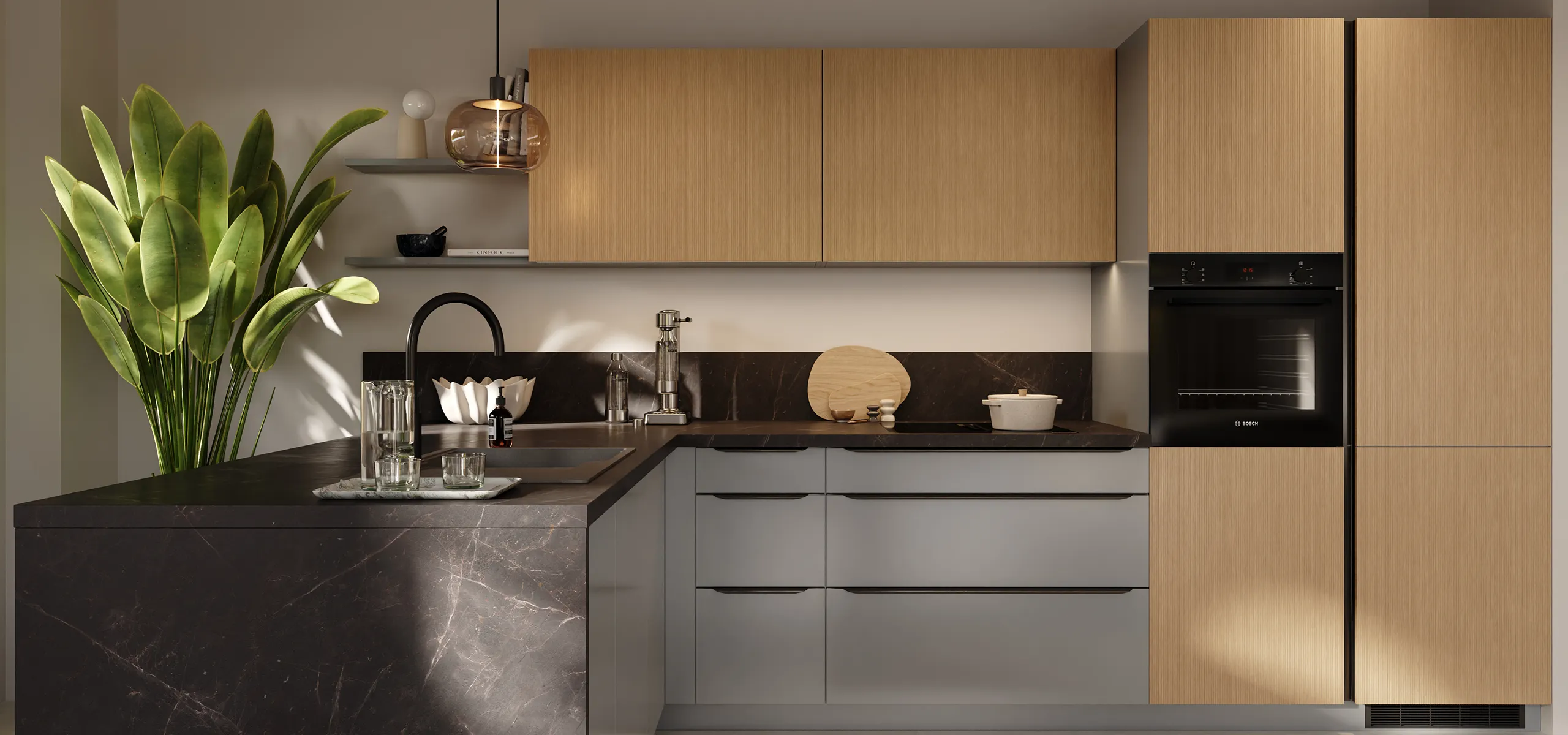 Moderne L‑Küche mit matten grauen Unterschränken, hellen Holzfronten und schwarzer Arbeitsplatte; Insel mit Spülbecken und schwarzem Wasserhahn, integrierter Bosch‑Backofen, Pendelleuchte, große Fensterbank mit Kissen, grüne Zimmerpflanze.